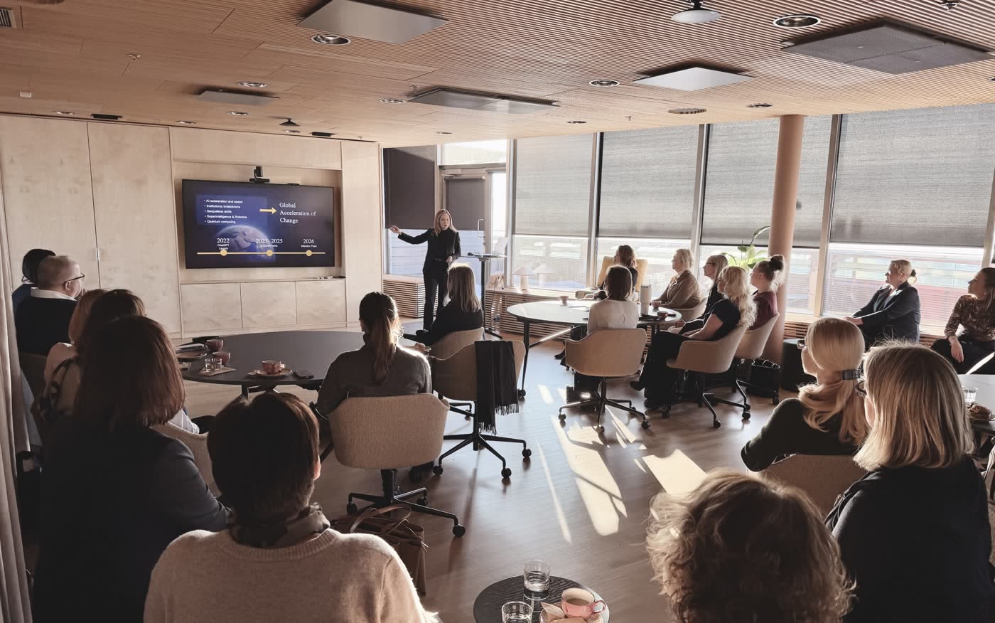 Tarja presenting to HR leaders in a wood-panelled Helsinki forum room