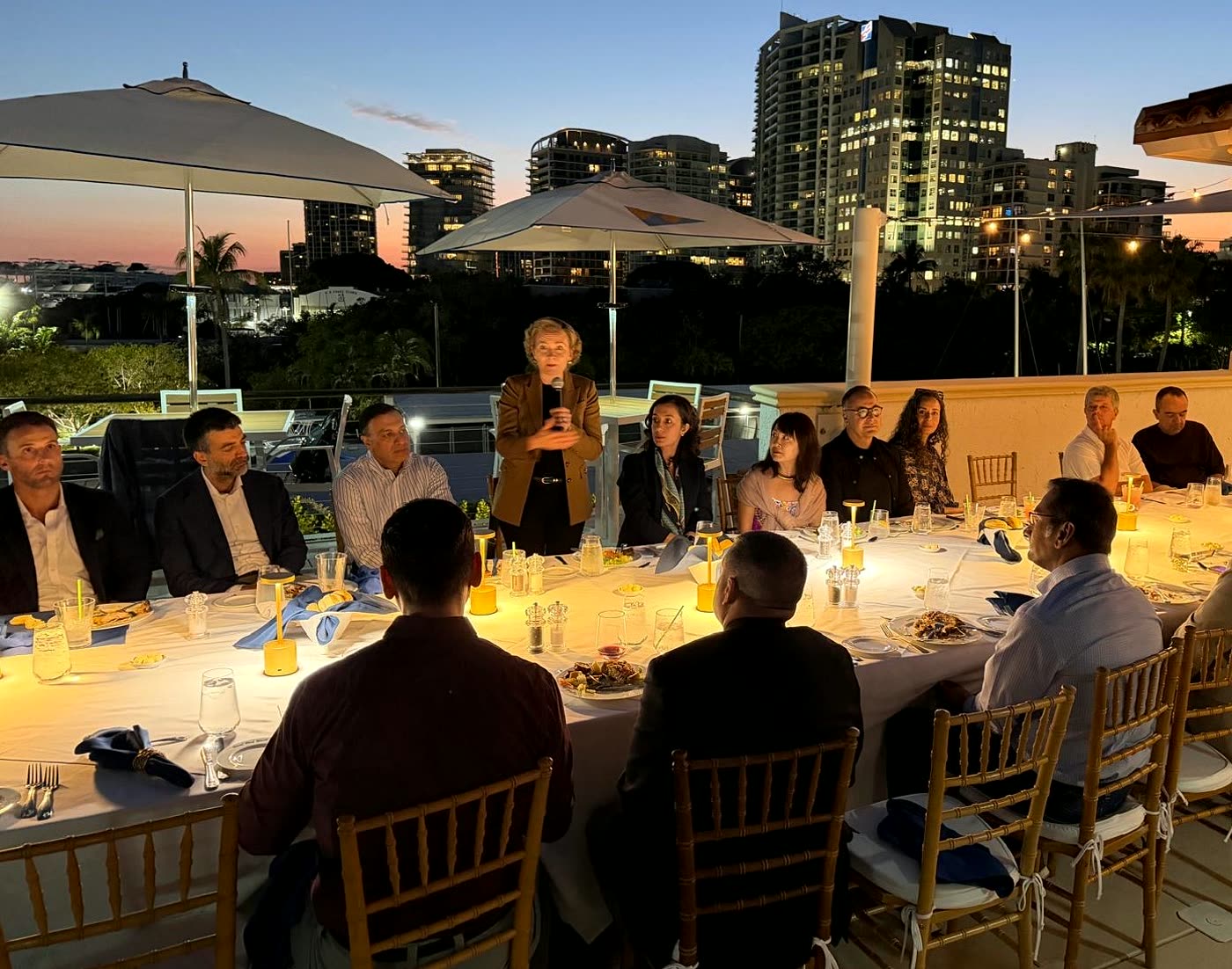 Tarja Stephens speaking at a rooftop dinner in Miami at dusk
