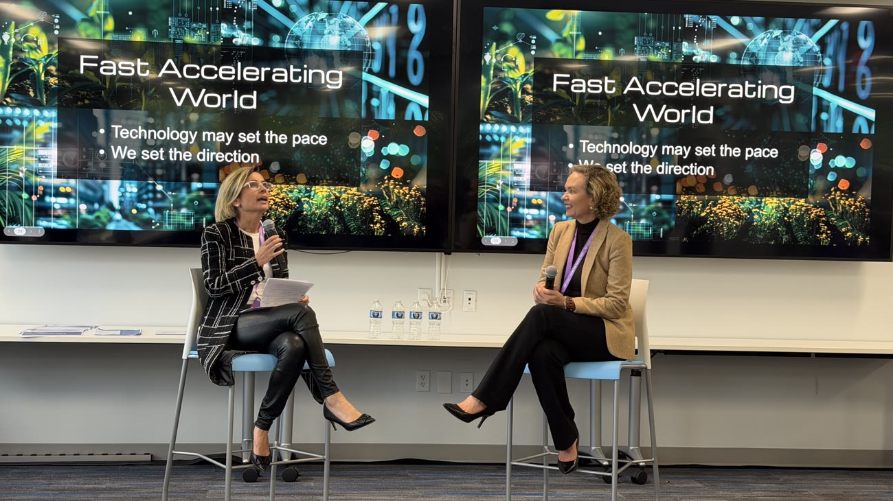 Tarja in a fireside conversation on bar stools under the slide Fast accelerating world.