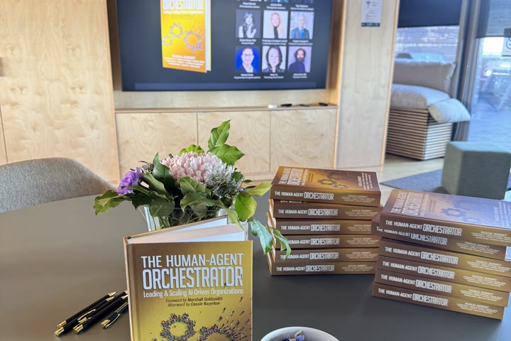 The book displayed on a table in front of a screen.