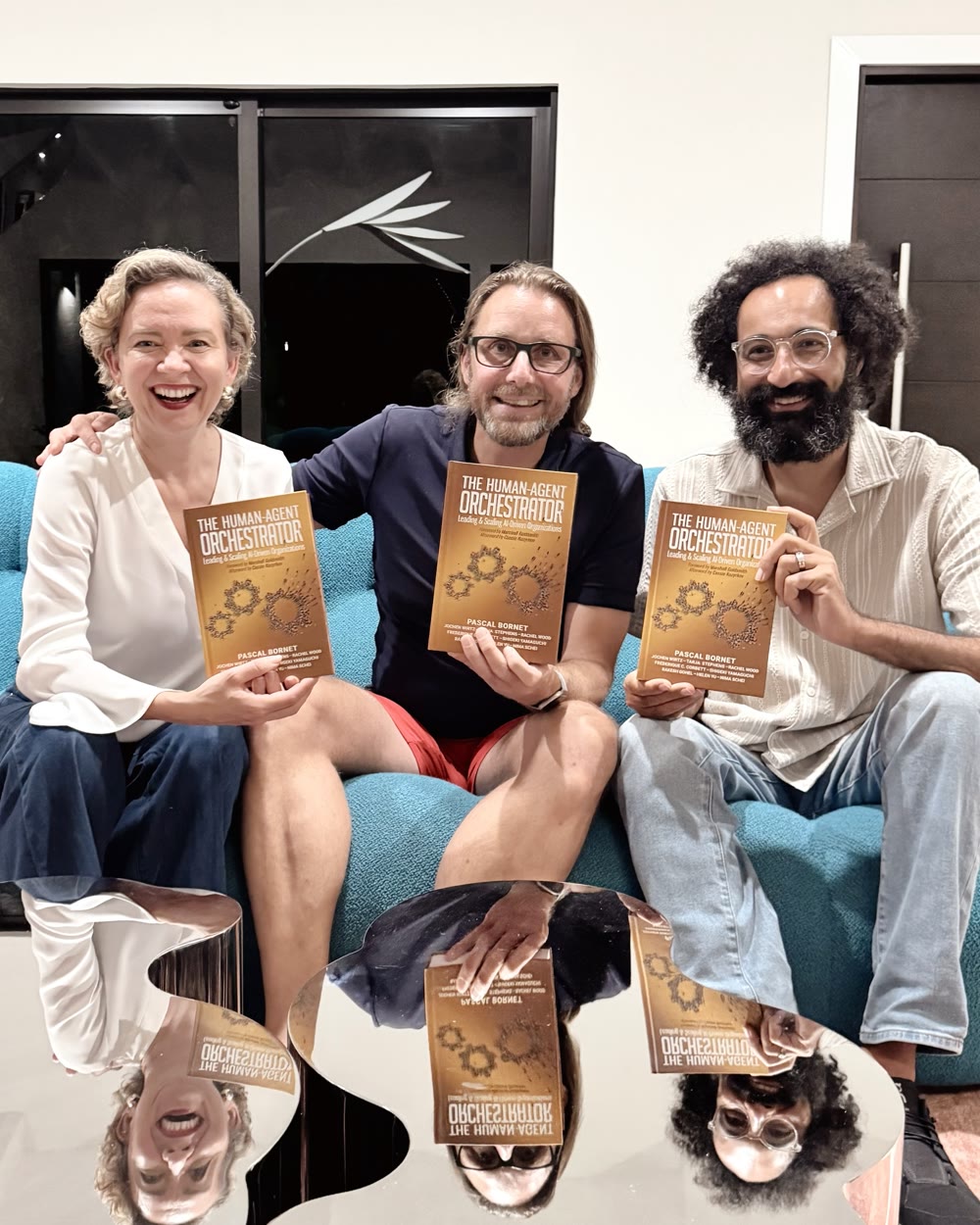 Tarja Stephens, Pascal Bornet and Nima Schei on a sofa in Miami, each holding a copy of the book.