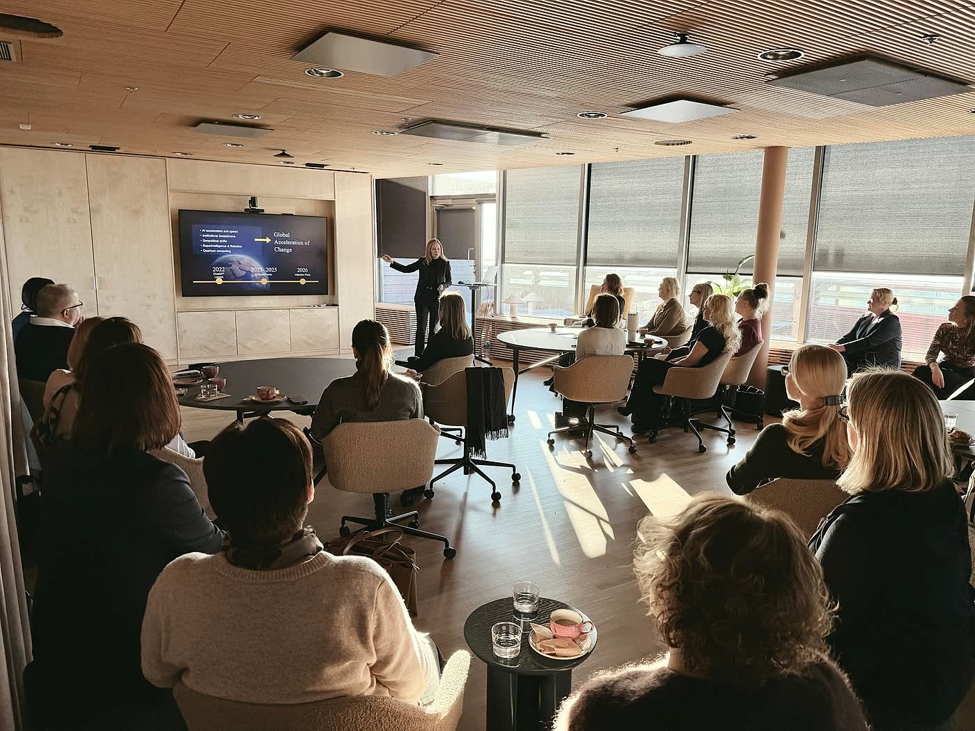 Tarja presenting to HR leaders at round tables in a Helsinki forum room