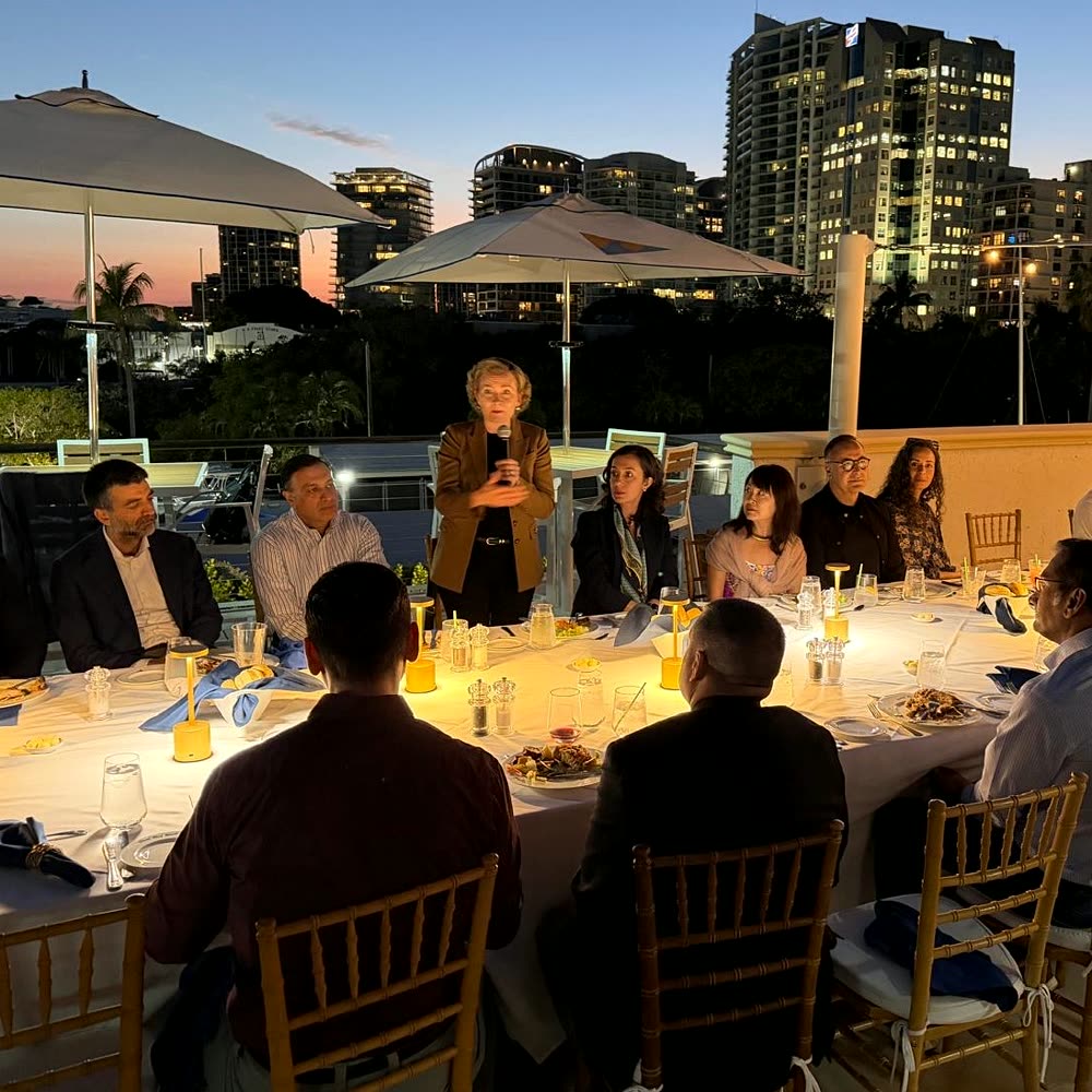 Tarja Stephens speaking at a rooftop dinner in Miami at dusk
